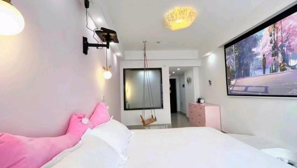 a bedroom with a large white bed with a pink headboard at Macaron in Zhangjiajie