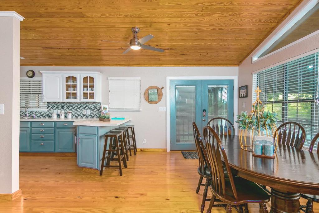 een keuken met blauwe kasten en een tafel en stoelen bij Riverfront Getaway On Guadalupe River in New Braunfels