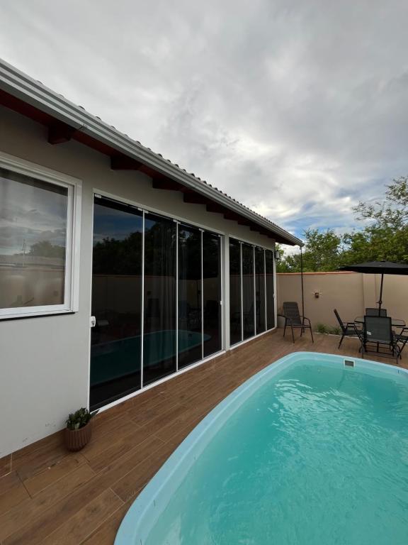 a swimming pool on a deck next to a house at Habitación Maninha in Pântano Grande