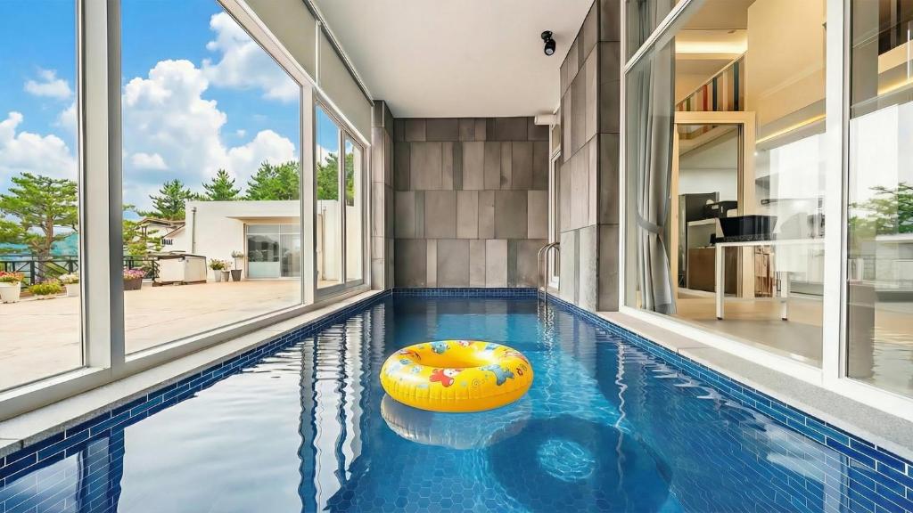 una piscina coperta con una palla gialla in una casa di Goseong Belloci Kids Poolivilla a Goseong