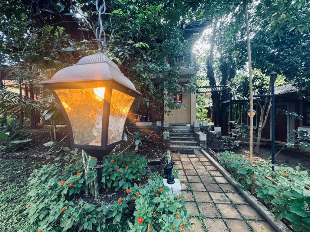 a light hanging over a garden with flowers at NILGIRA VILLA By LILYS in Badulla