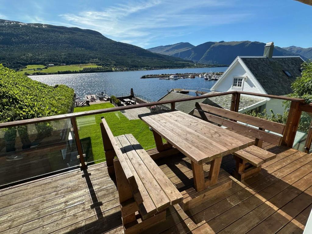 eine Holzterrasse mit einem Picknicktisch und Seeblick in der Unterkunft 4 star holiday home in Eidsvåg in Eidsvåg