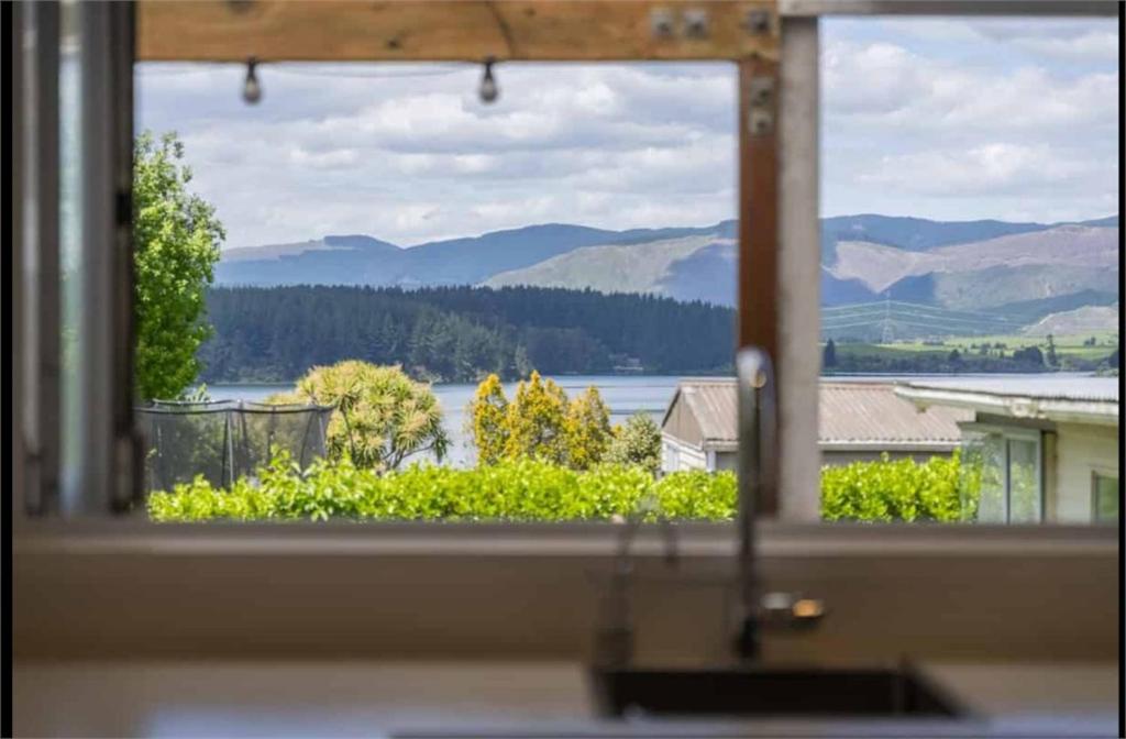 ein Fenster mit See- und Bergblick in der Unterkunft Modern Lake View House in Mangakino