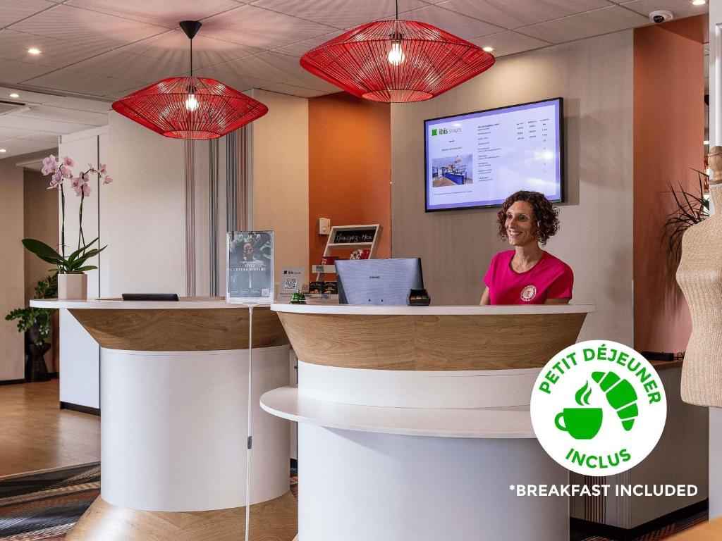 a woman sitting at a counter in an office at ibis Styles Toulouse Lavaur in Lavaur