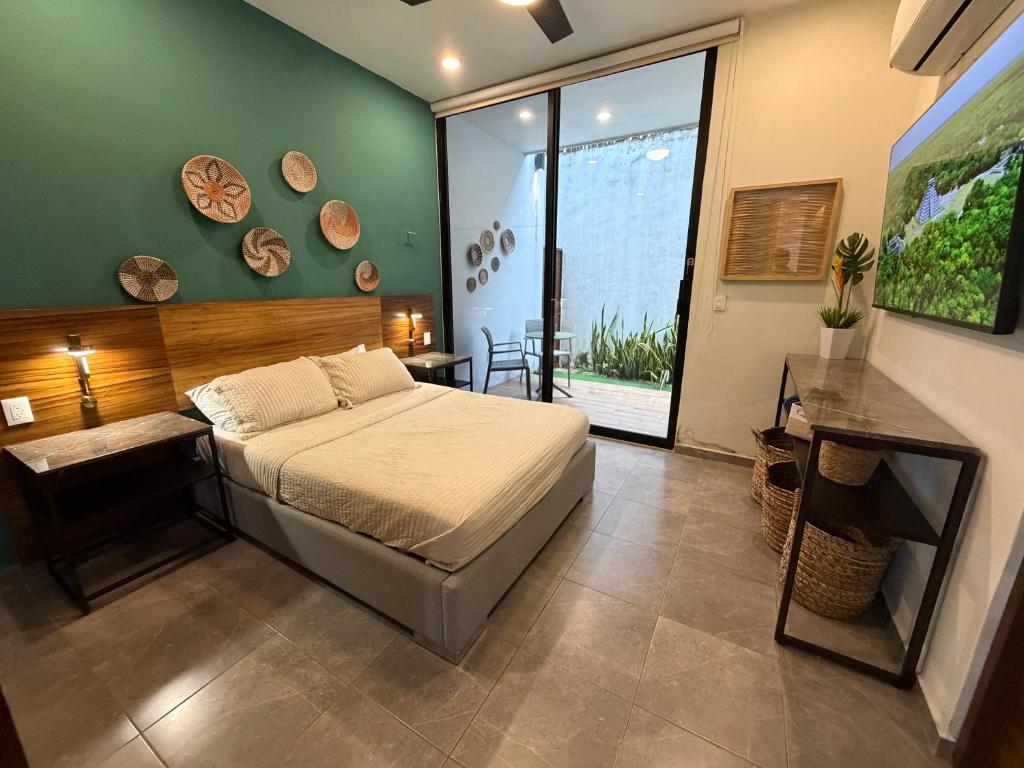 ein Schlafzimmer mit einem Bett und einem großen Fenster in der Unterkunft Penca Suites Valladolid in Valladolid