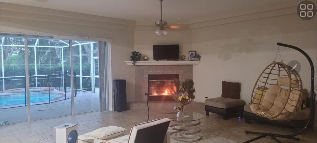 een woonkamer met open haard en een bank bij Cozy room with HEATED POOL & SPA -HOT TUB for relaxation in Valrico