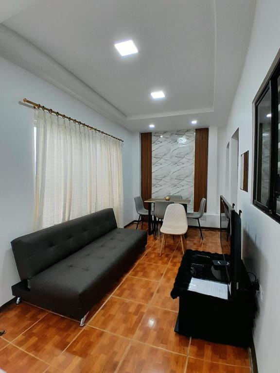 a living room with a black couch and a table at Suite cerca de la UTPL y Centro Histórico in Loja
