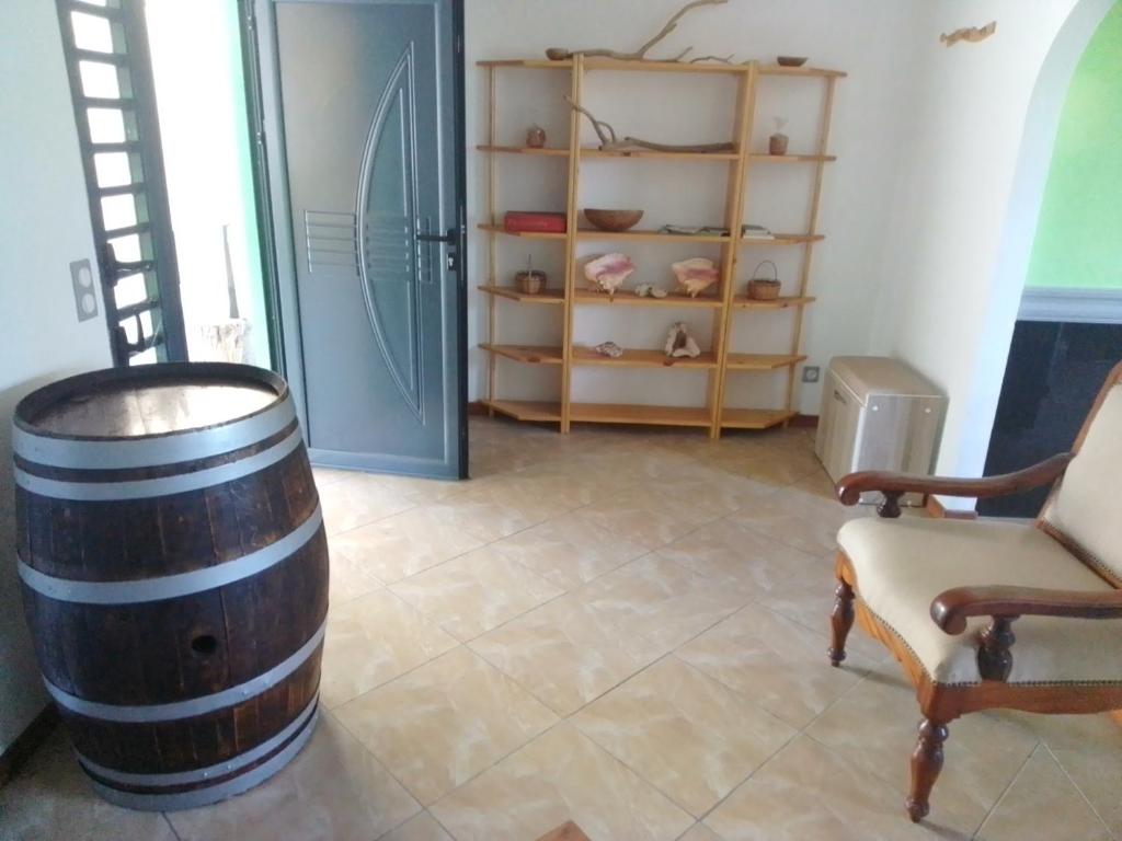 een kamer met een wijnvat, een stoel en planken bij kaz a gabou in Sainte-Rose