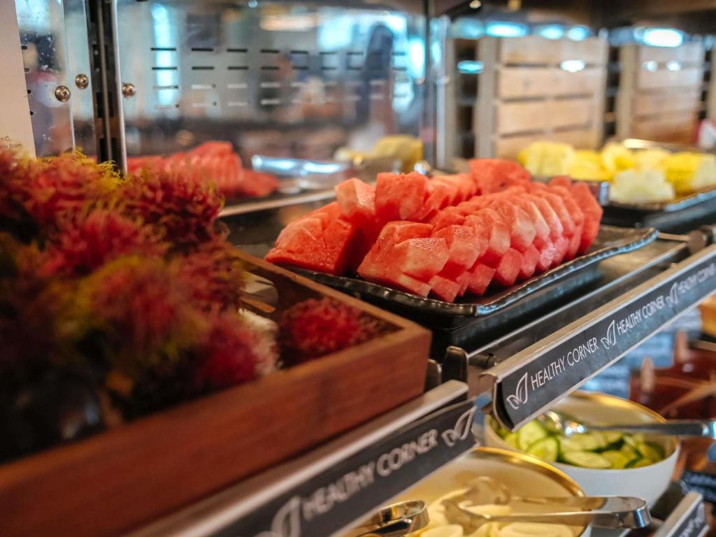 A buffet display presents sliced fruit and other chilled breakfast items.