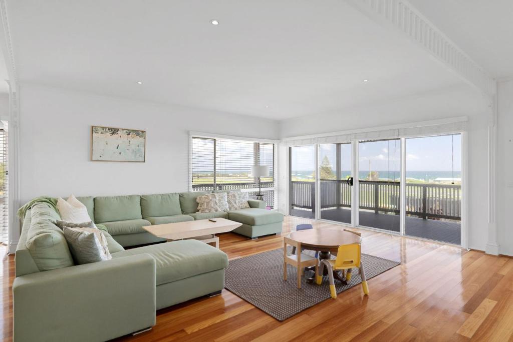 een woonkamer met een bank en een tafel bij Oceanfront Escape Kilcunda in Kilcunda