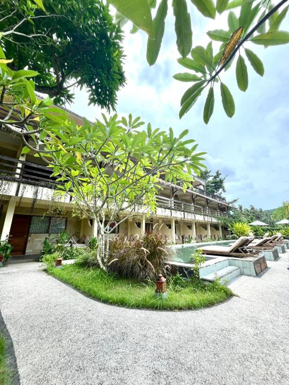 a building with a tree in front of it at Mango Selong in Selong Belanak
