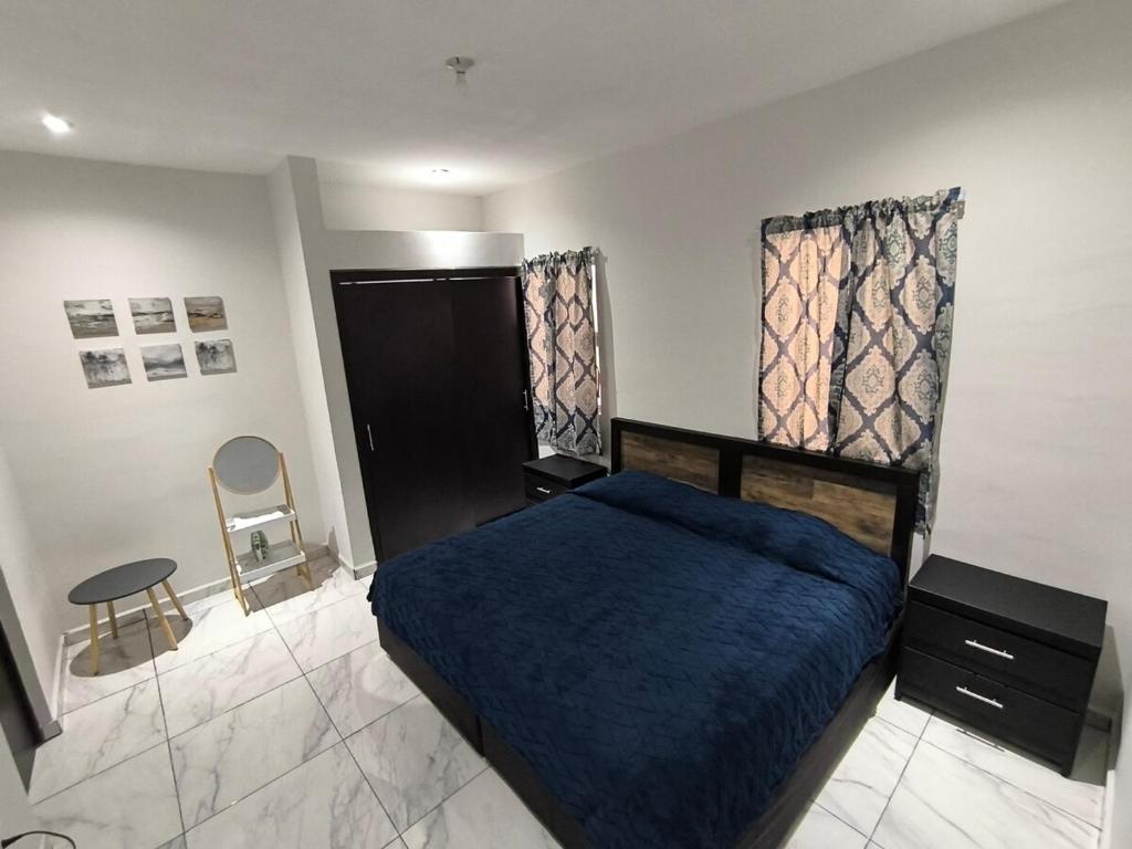 a bedroom with a blue bed and a chair at Descanso y Comodidad en Reynosa in Reynosa