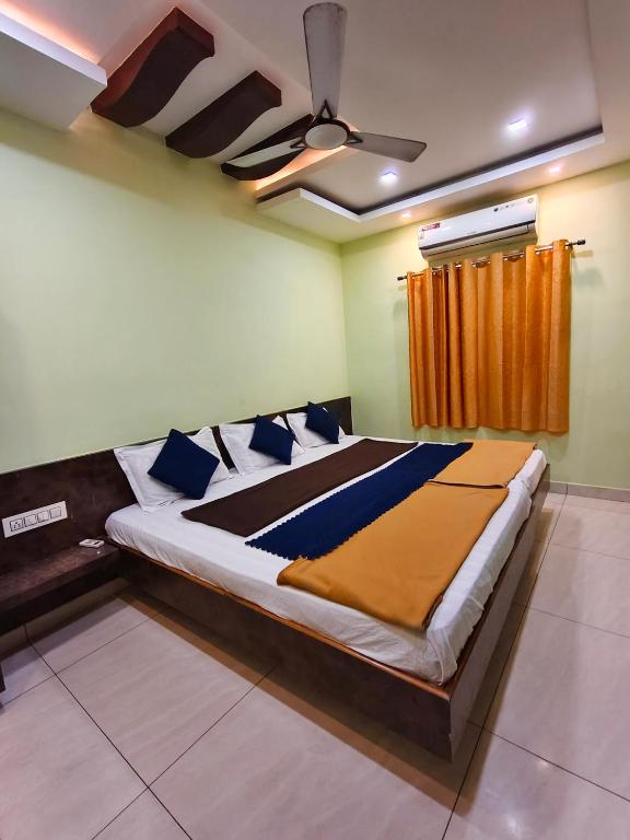 ein großes Bett in einem Zimmer mit einer Decke in der Unterkunft Galaxy Beach Residency in Velankanni