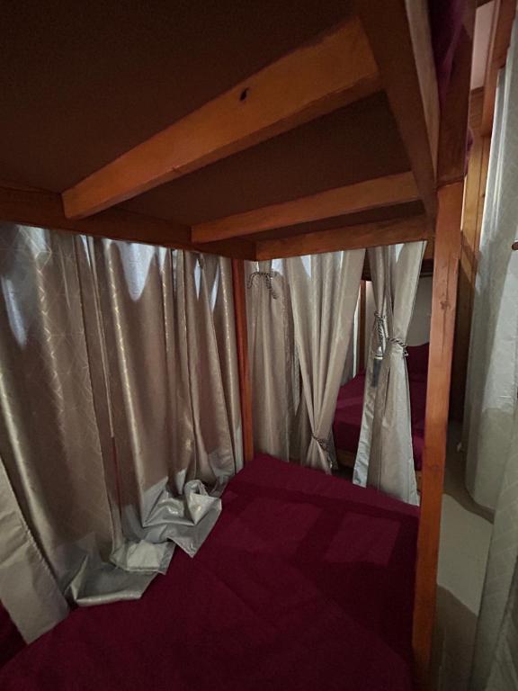 a small bed in a room with curtains at Dadhwal Zostel in Dharmsāla