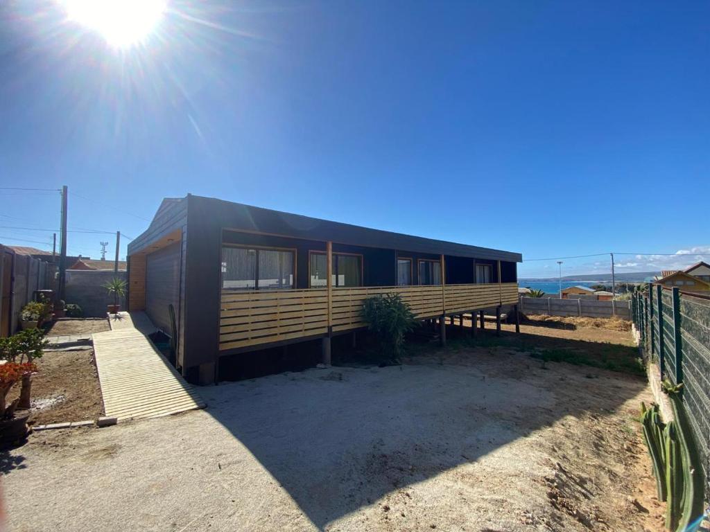 een zwart huis met de zon op de achtergrond bij playanorte in Choapa