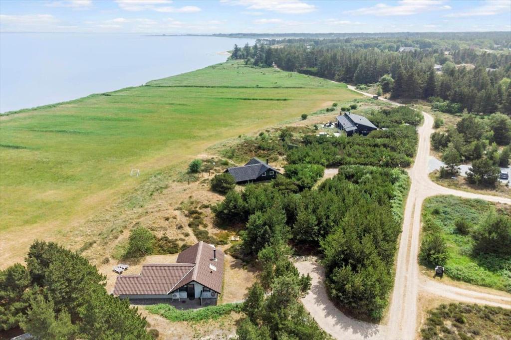 een luchtfoto van een huis op een heuvel naast het water bij 2555-Romo-A-M-Listsvej-6 in Tagholm