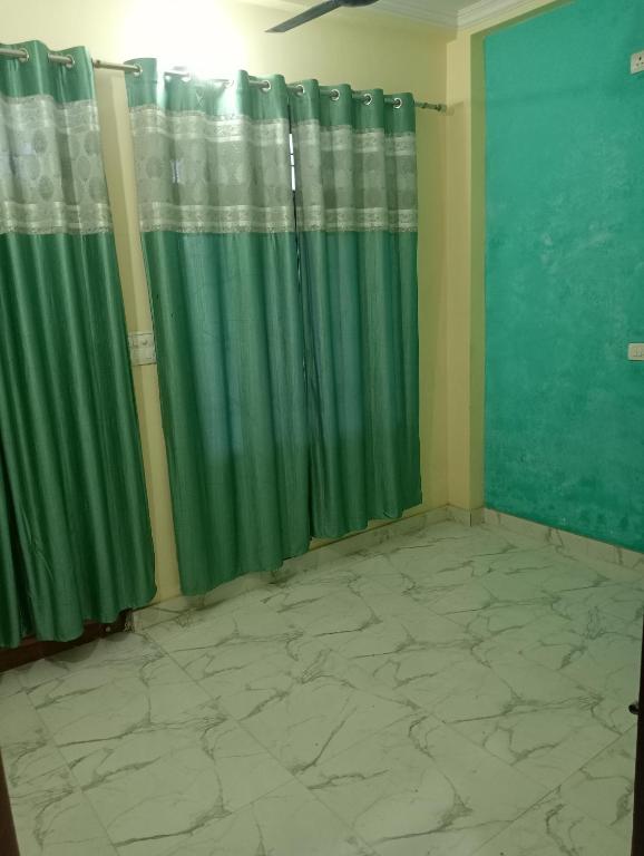 a green curtain in a room with a tile floor at Om Mansion in Varanasi