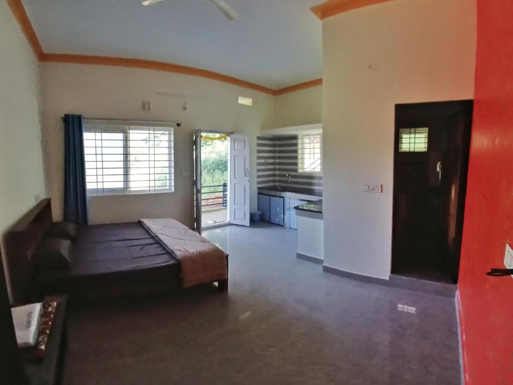 een grote slaapkamer met een bed en een keuken bij The Town Cascade in Madikeri