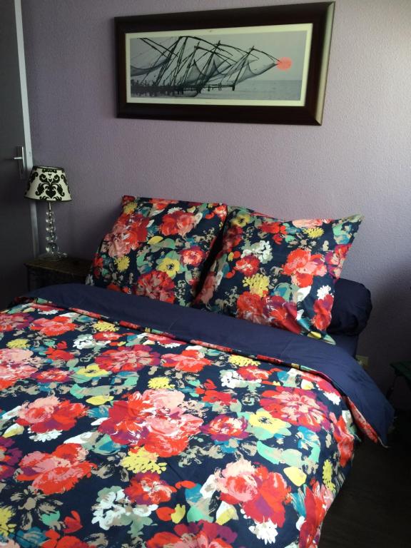 ボルドーにあるAppartement proche Victoireのベッドルーム1室(花柄の掛け布団付きのベッド1台付)