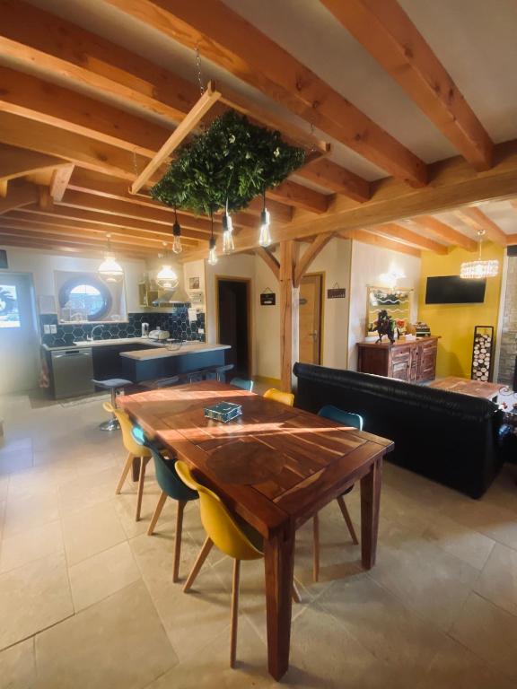 a dining room with a wooden table and chairs at La Longère des Oies in Saint-Thibault