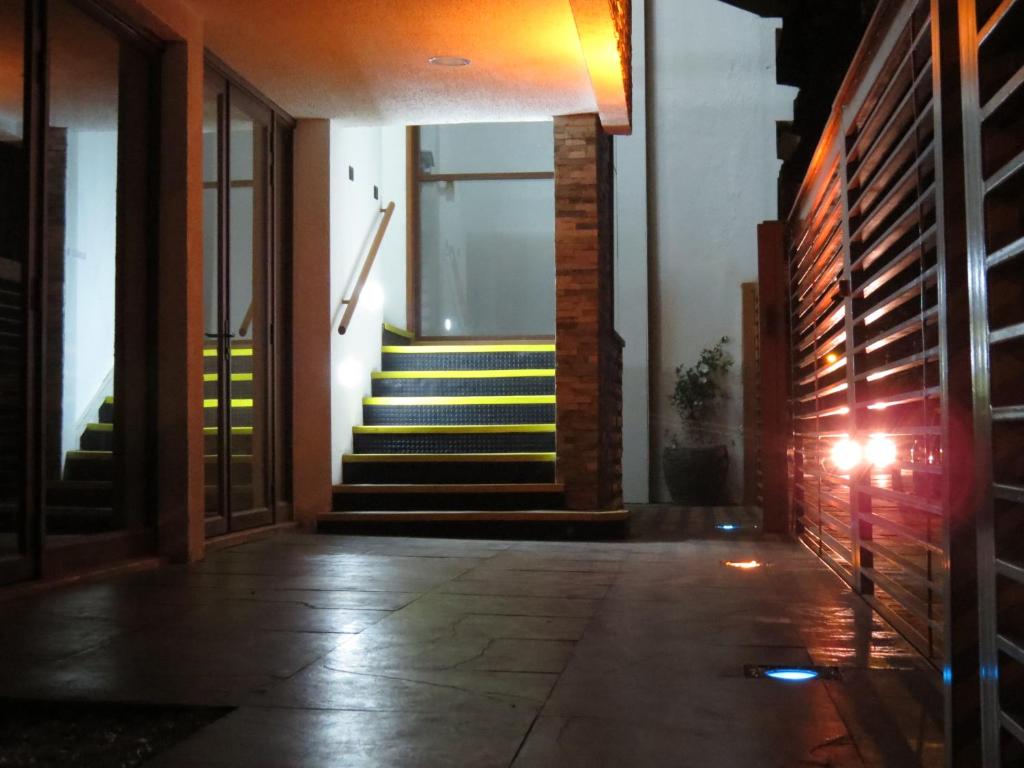 a hallway with stairs in a house at night at Apart Hotel Uman in Concepción