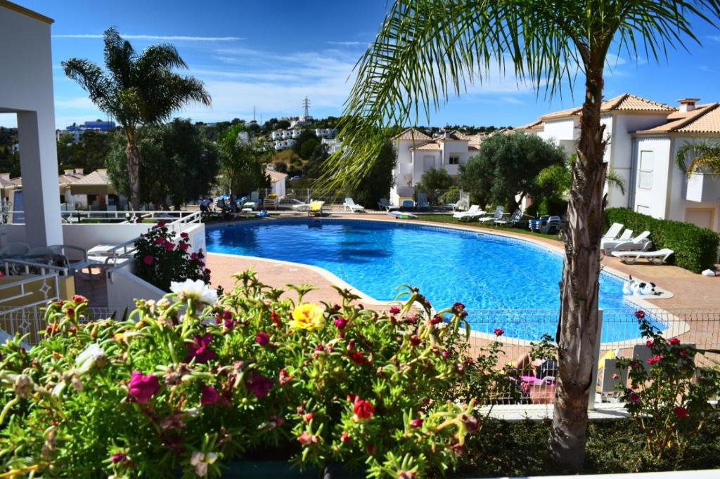 a swimming pool in a villa with flowers at Villa Algarve- Townhouse in Farm Village, Albufeira in Albufeira