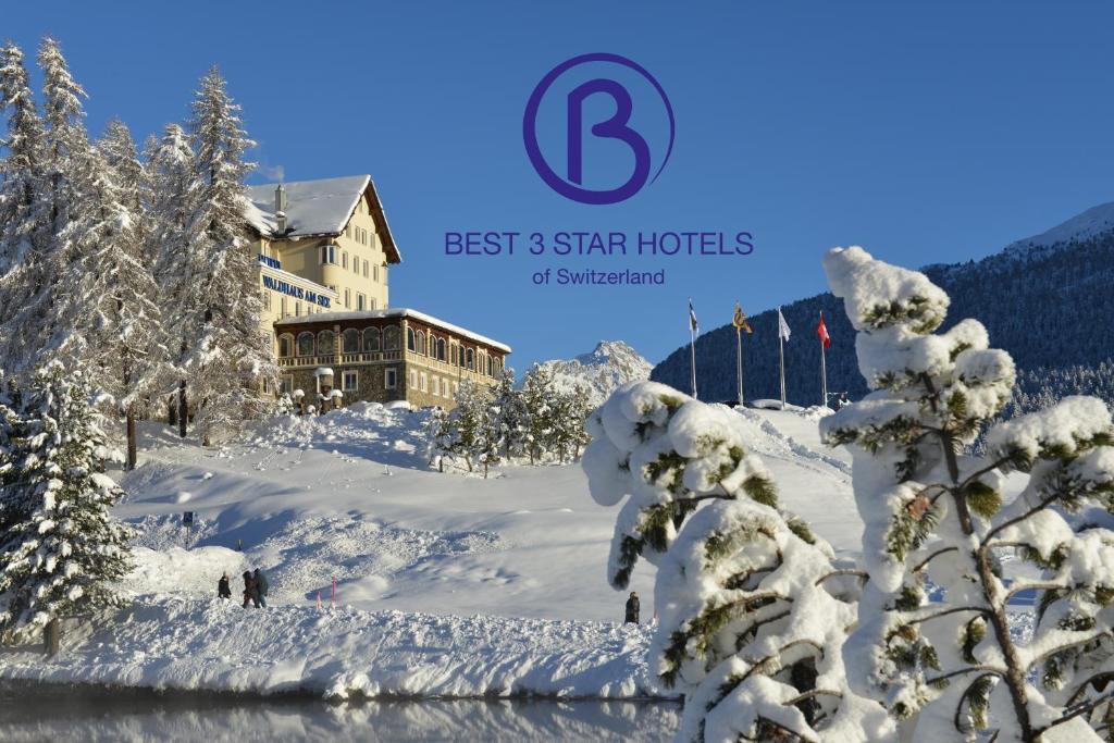 un rifugio da sci nella neve con alberi innevati di Hotel Waldhaus am See a Sankt Moritz