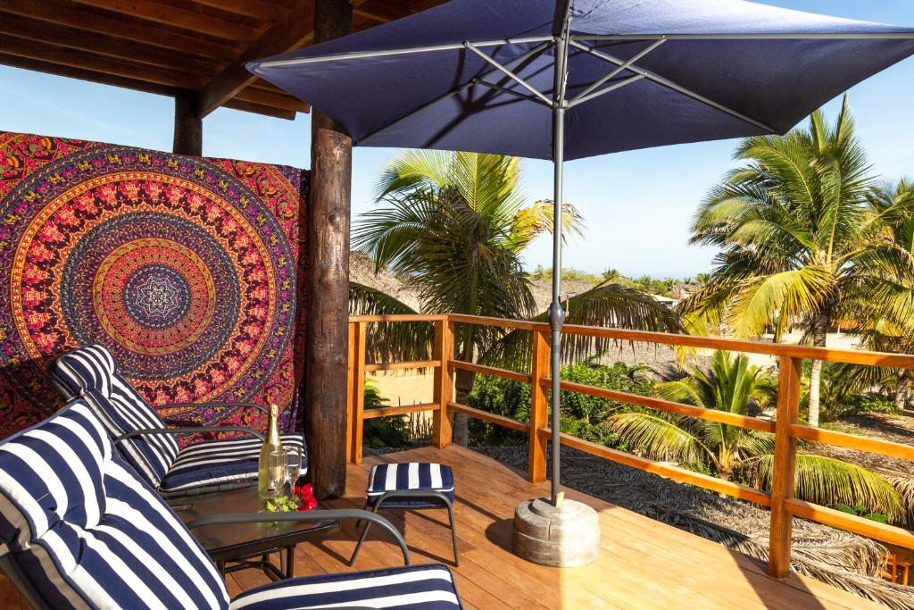 - une terrasse couverte avec 2 chaises et un parasol dans l'établissement Olas y Arena, à Vichayito