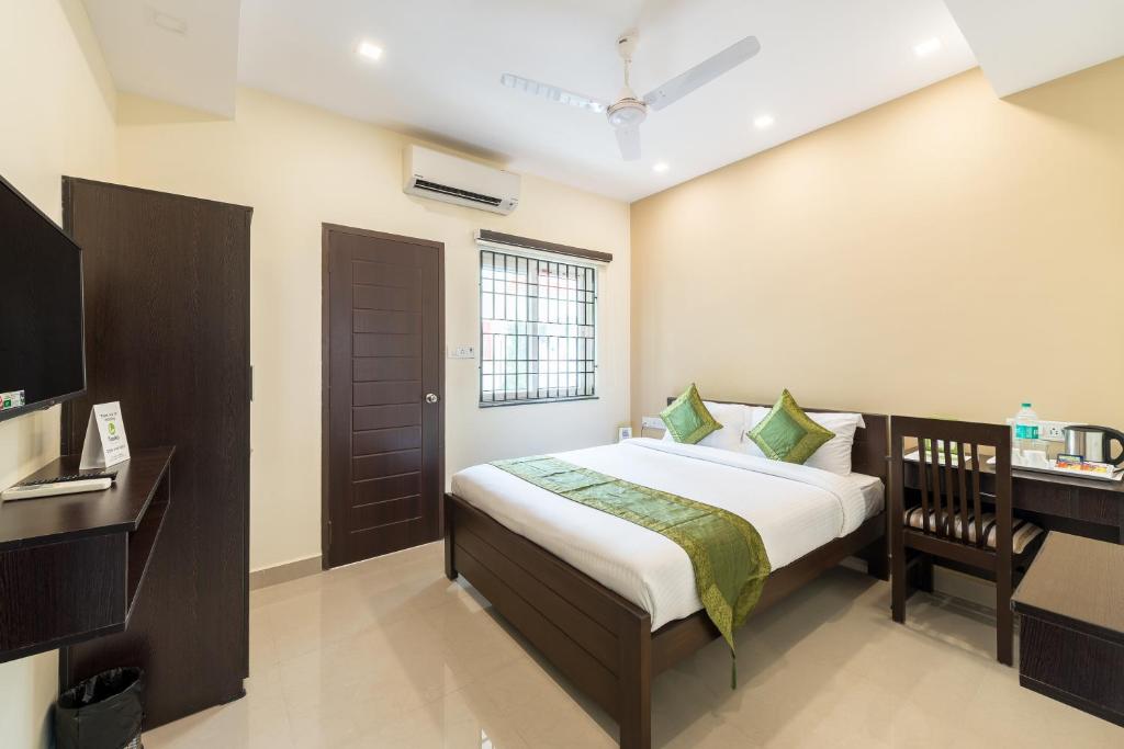 um quarto com uma cama, uma secretária e uma televisão em Treebo Trend Adin Residence Chennai Trade Centre em Chennai