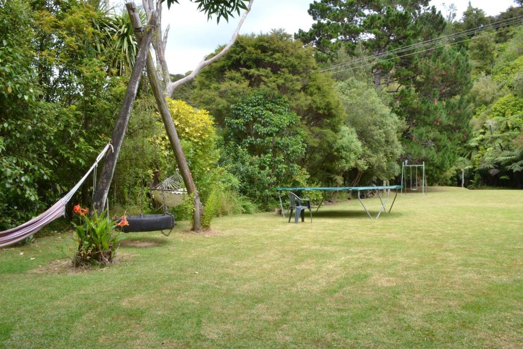 a park with a hammock and a swing set at Te Mata Lodge in Tapu