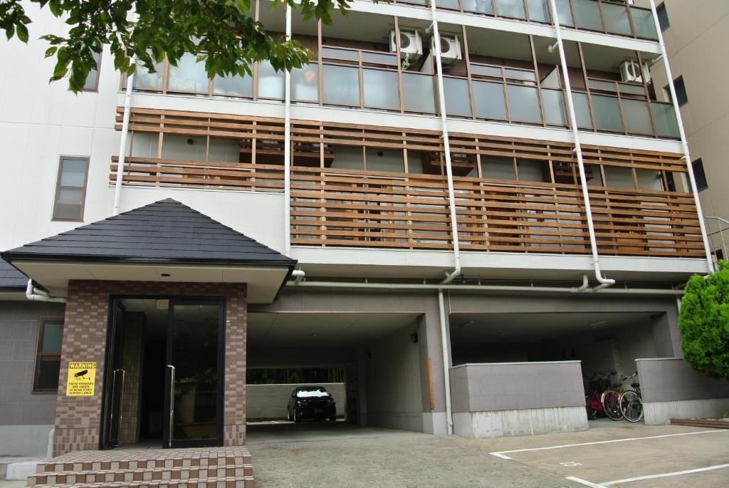 a large building with a parking garage in front of it at Backpackers Hotel NOOSA JAPAN in Takatsuki Tonda in Takatsuki