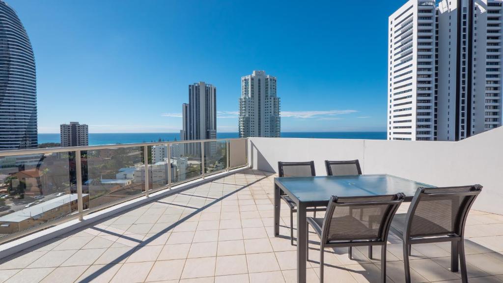 a balcony with a table and chairs on a roof at Broadbeach Savannah Resort in Gold Coast