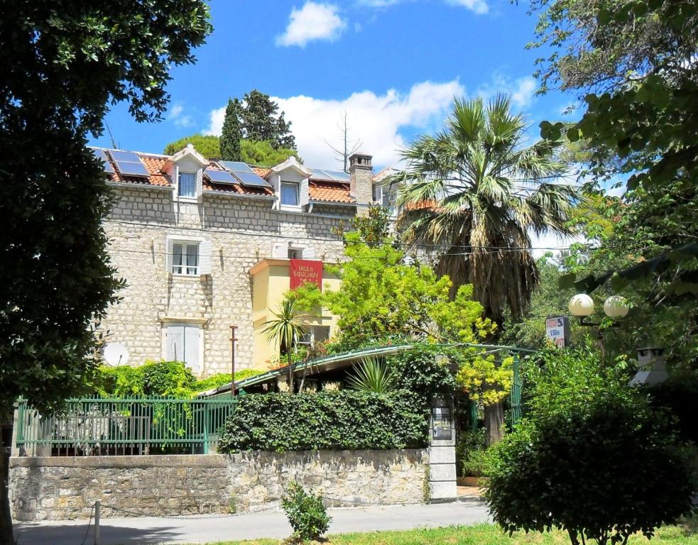 a large stone building with a fence and trees at Villa Šoulavy in Kaštela