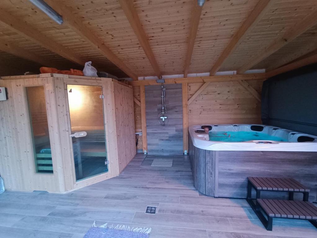 een sauna met een hot tub in een houten gebouw bij Szóládi Vendégház in Szólád