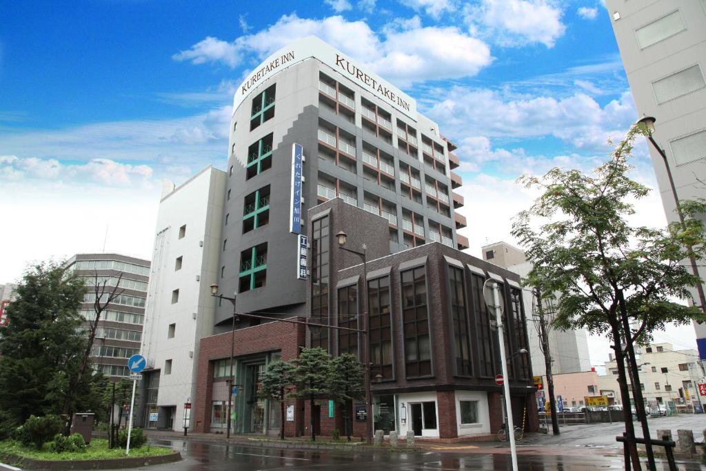 a tall white building on a city street at Kuretake Inn Asahikawa in Asahikawa