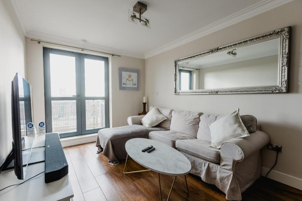 a living room with a couch and a mirror at Hullidays - King & Queen Ensuite in Hull