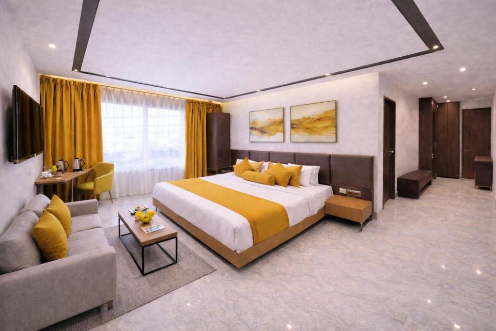 a hotel room with a large bed and a couch at Hotel Apple Wood Delhi Airport With Free Airport Drop in New Delhi