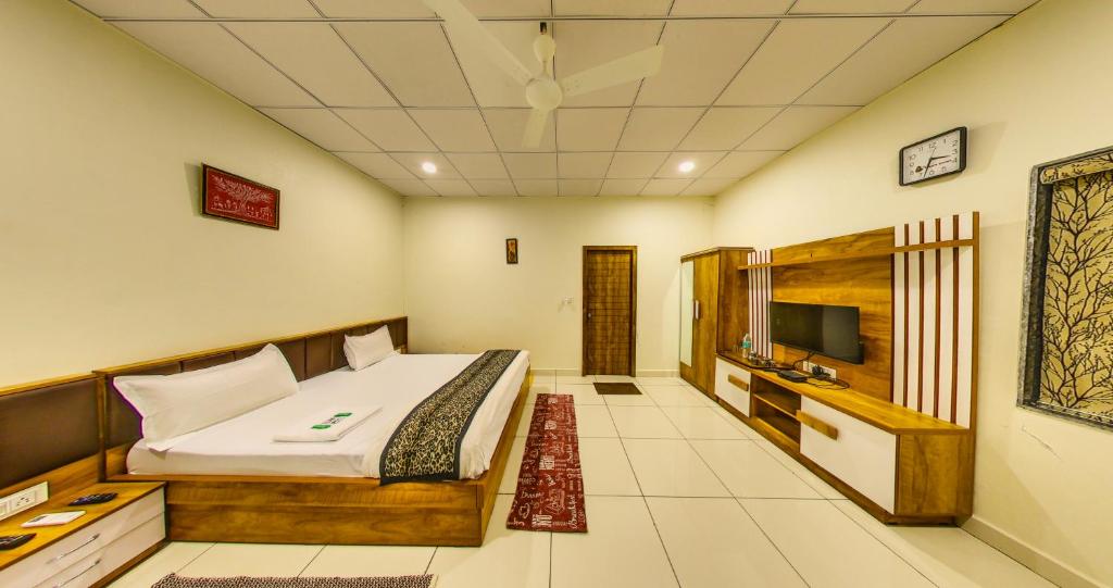 a bedroom with a bed and a television in it at Tejas Gir Villas in Sasan Gir