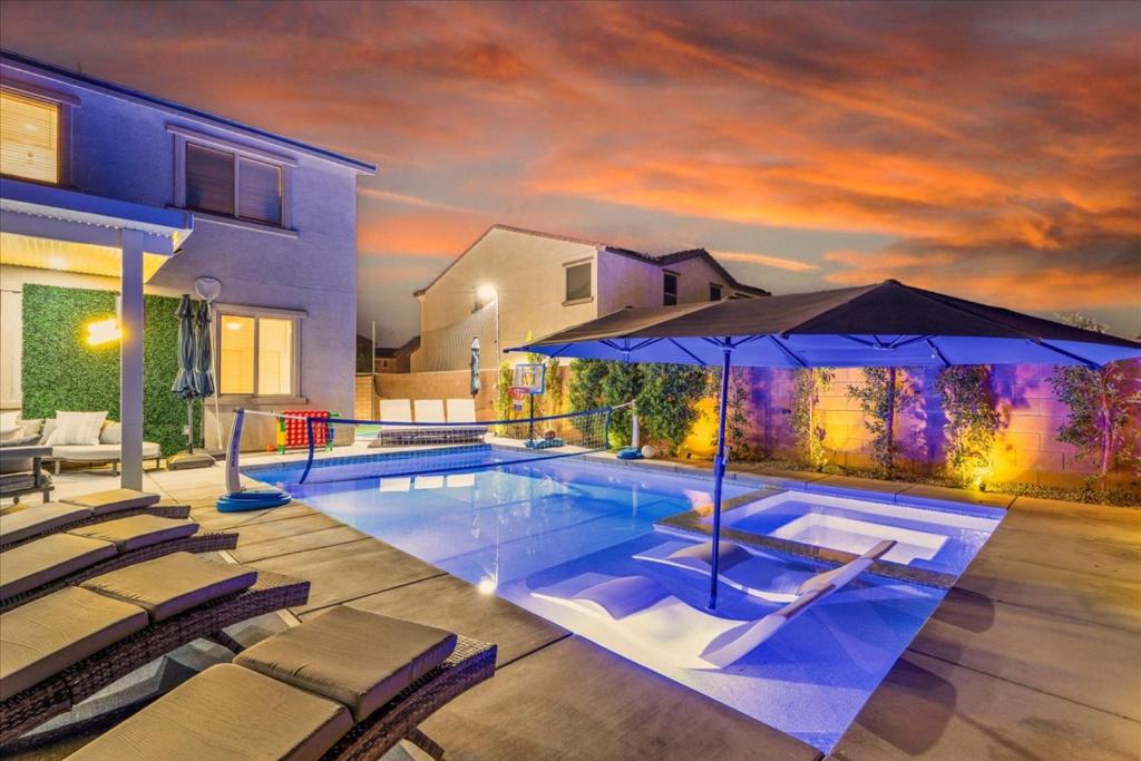 a swimming pool with chairs and an umbrella at Oh la la Coachella in Coachella