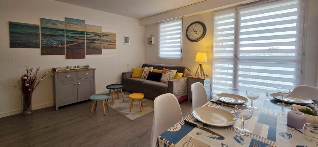 ein Wohnzimmer mit einem Sofa und einem Esstisch in der Unterkunft ESCAPADE FAMILIALE A LA MER in Quiberon
