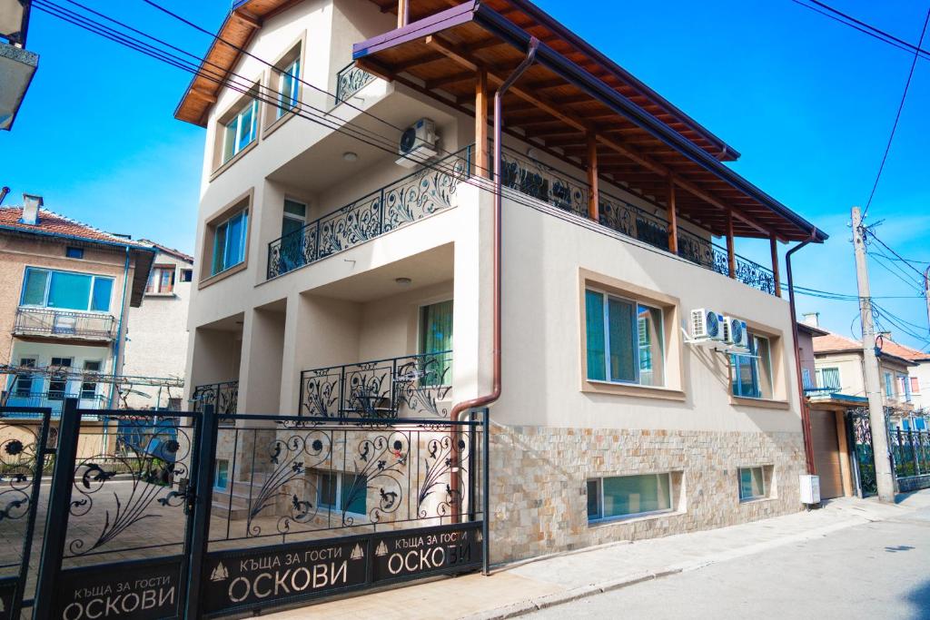a building with balconies and a fence at Къща за гости Оскови in Velingrad