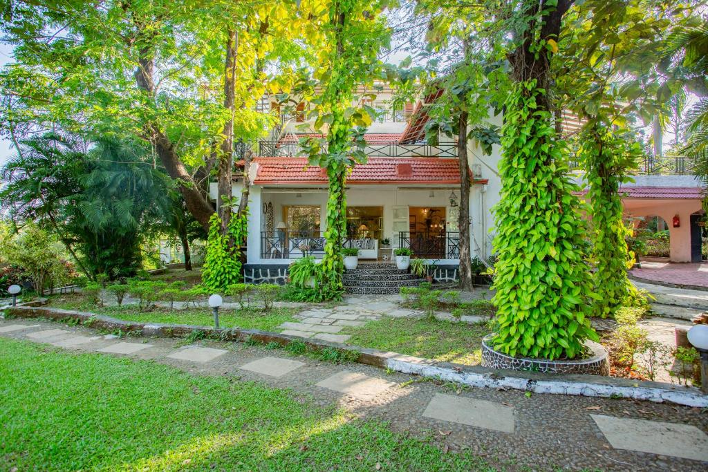 Ein Haus mit Efeu auf der Vorderseite in der Unterkunft Kenwood's Farmstay - 6bhk with private pool in Zadapoli