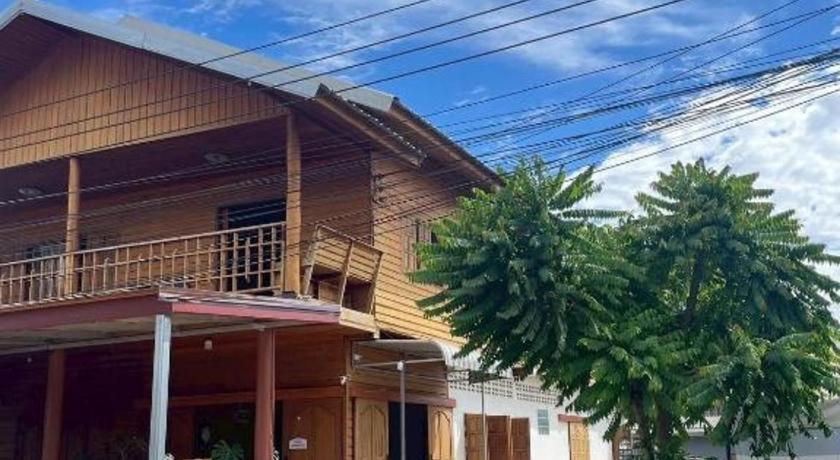 een huis met twee palmbomen ervoor bij Le Moon Hotel in Chiang Khan
