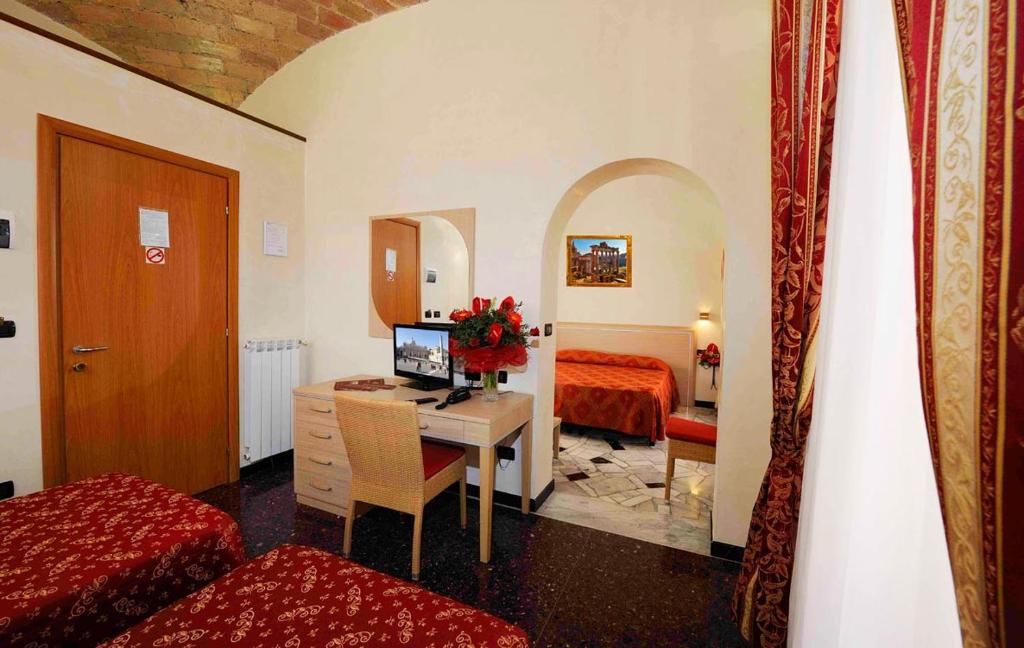 a bedroom with a desk with a computer and a bed at Hotel Campidoglio in Rome