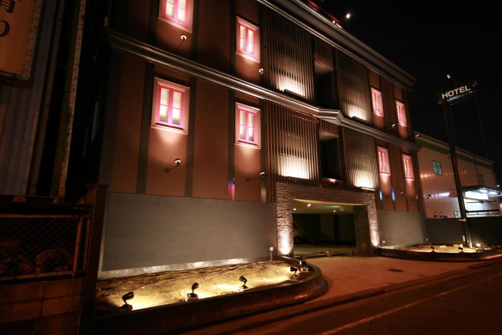 un edificio con pájaros sentados fuera de él por la noche en ホテル アンジュエトワール 堺 - Adult Only, en Sakai