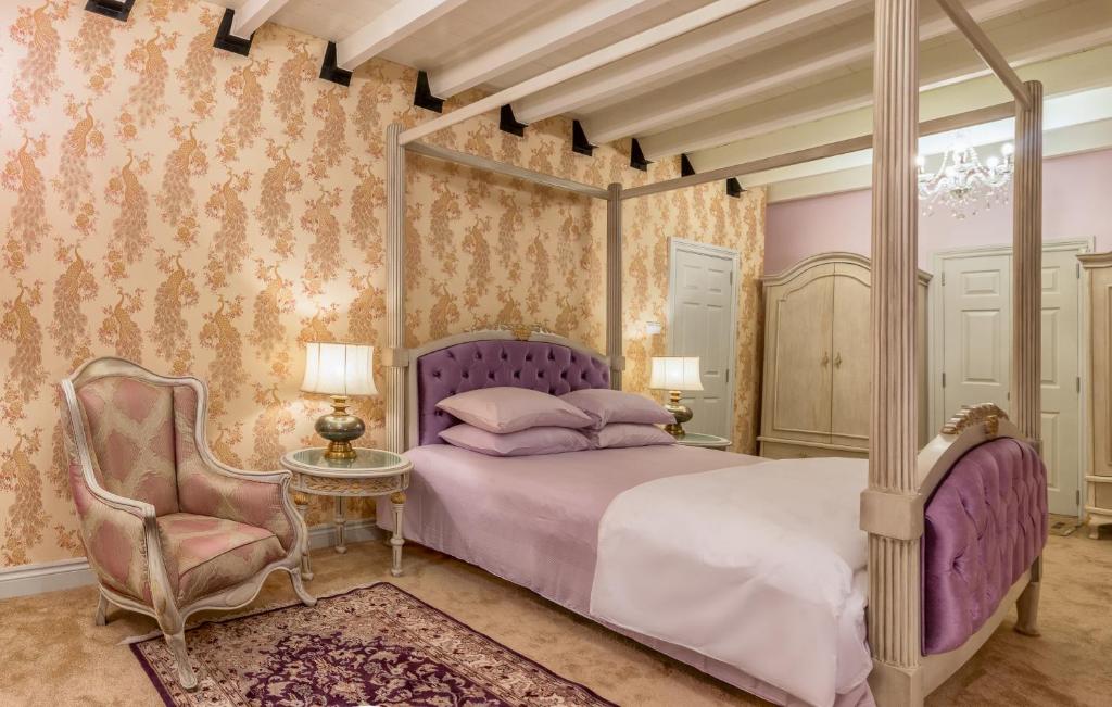努沃勒埃利耶的住宿－肯特小屋酒店，一间卧室配有一张天蓬床和一把椅子