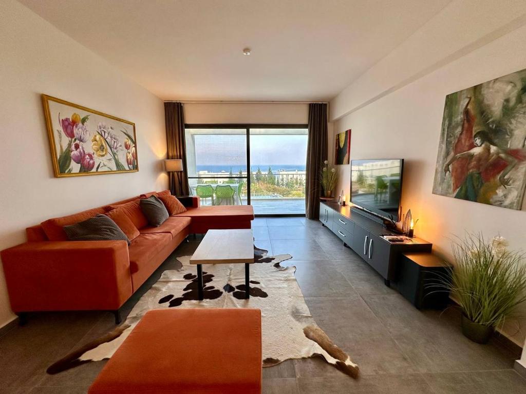 een woonkamer met een bank en een televisie bij Retreat block A2, unit 6 in Küçükerenköy