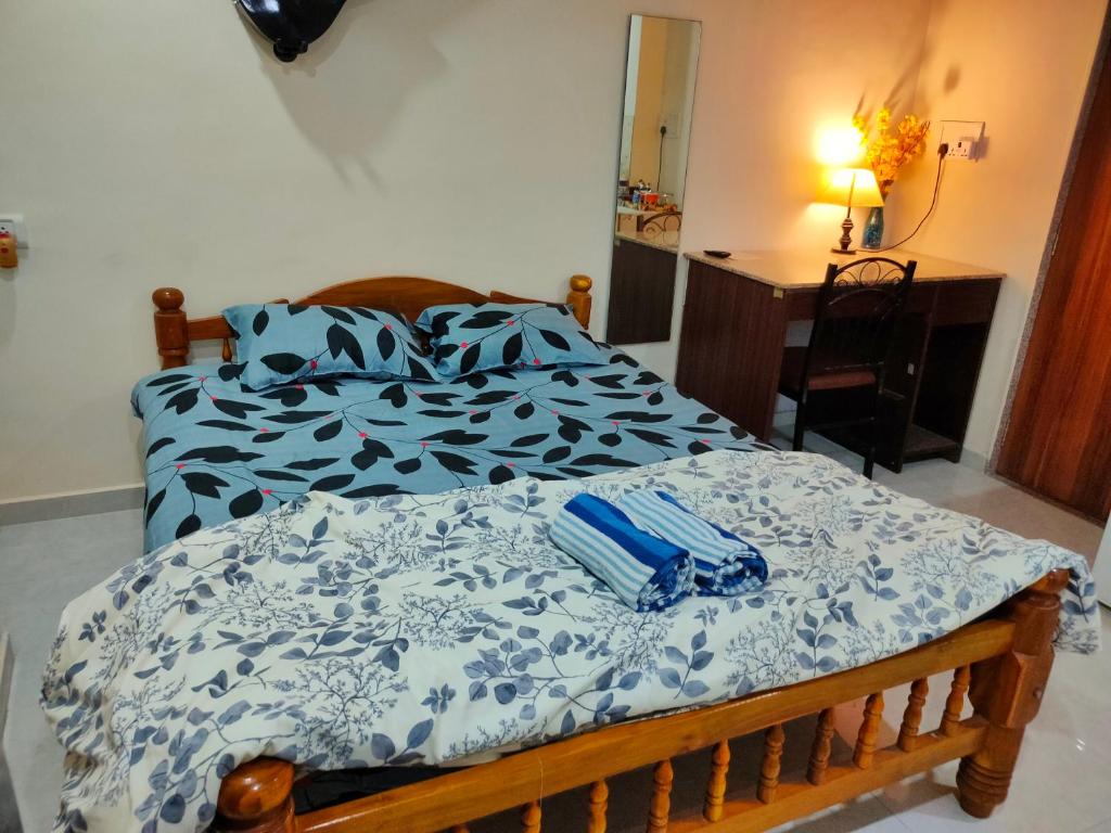 een slaapkamer met een bed met een blauw en wit dekbed bij Ebony Room - Comfortable Suite in Mumbai