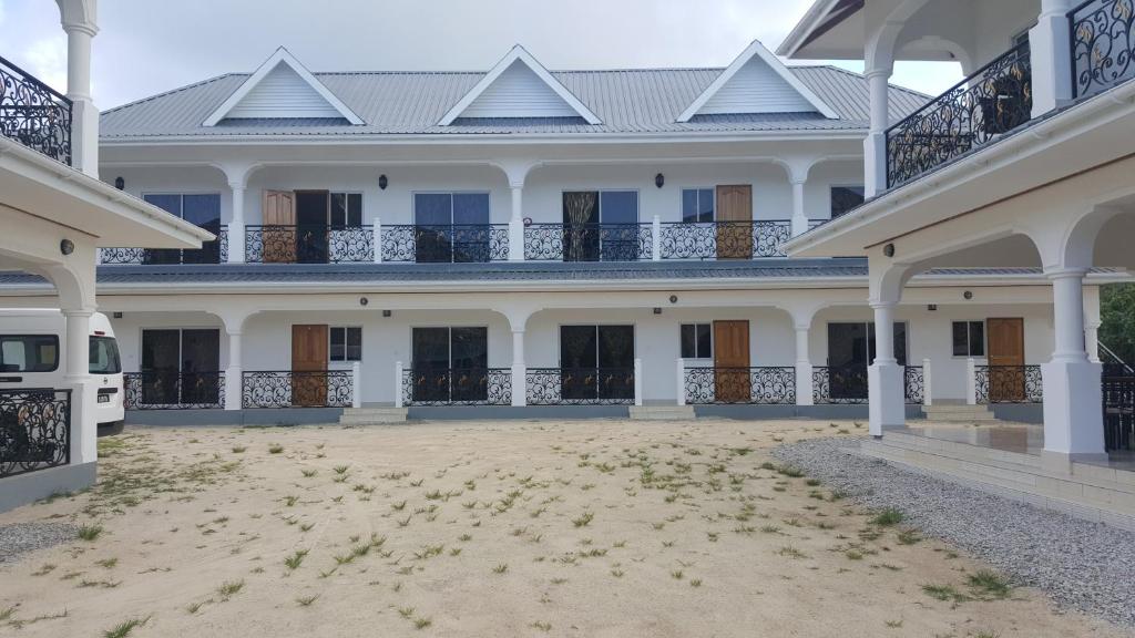ein großes weißes Haus mit einem großen Innenhof in der Unterkunft Casadani Luxury Apartment in Grand Anse