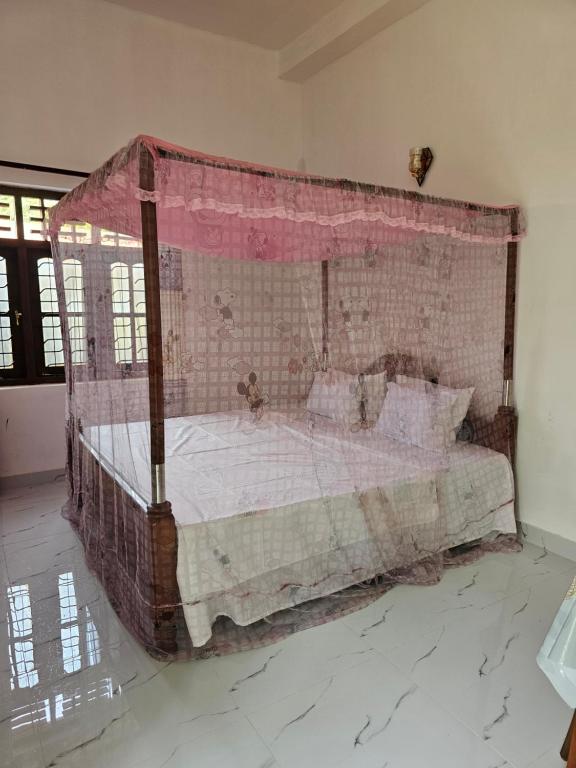 a large bed with a canopy in a room at Pradeepa Villa in Weligama